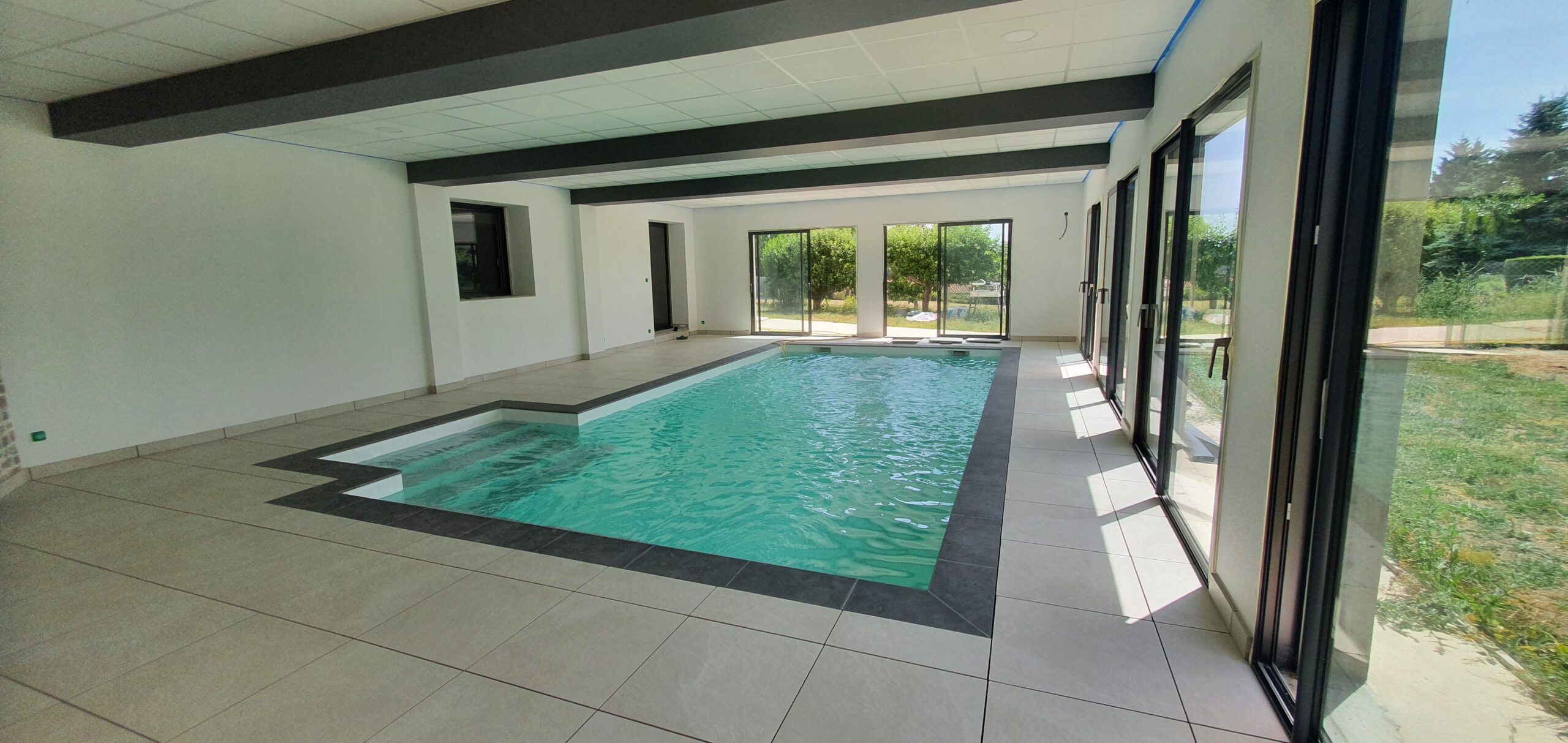 Piscine intérieure 8 × 4 m avec escalier déporté — construction sur mesure